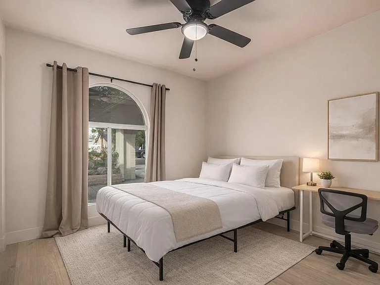 Queen bed, desk, chair, lamp, fan, closet. Bedding and rug are virtually staged.