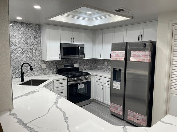 Recently remodeled kitchen ( never been used) with new refrigerator, dish washer, microwave, oven, cabinets, sink, faucet, flooring, lights, and back splash.