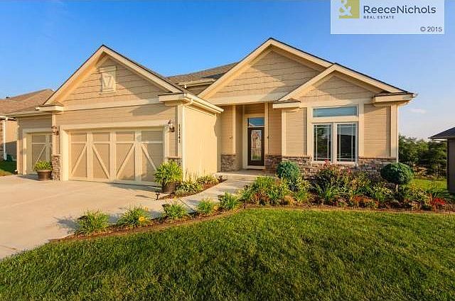 Beautiful landscaping surrounds an even more picturesque home wi