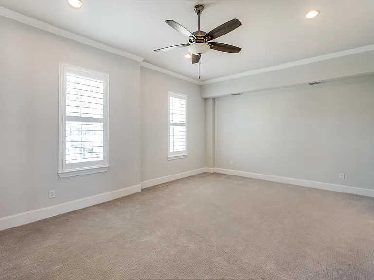 The primary bedroom is oversized, features premium carpet, plantation shutters and an en-suite bathroom and walk-in closet.