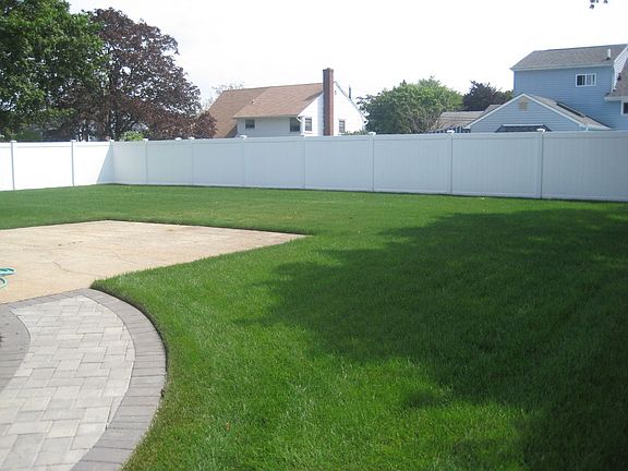 new sod lawn and white pvc fence
