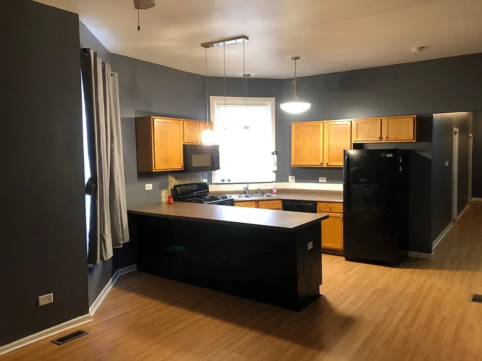 Kitchen area with island, ample cabinet space, newer appliances and new lighting over the island, sink and counters.