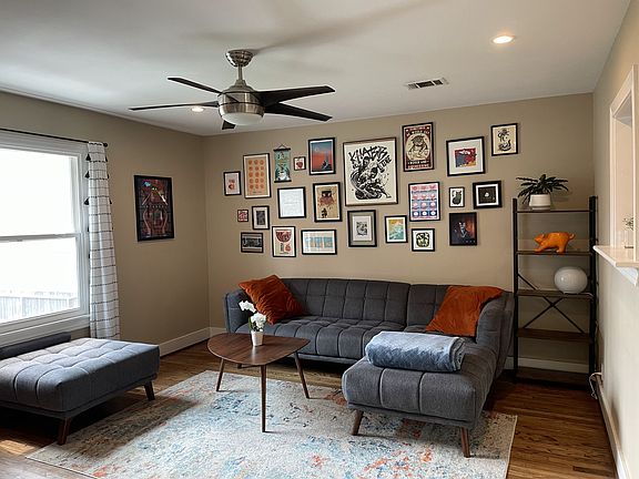 Stairs lead to large living room with window overlooking front yard (rents unfurnished).