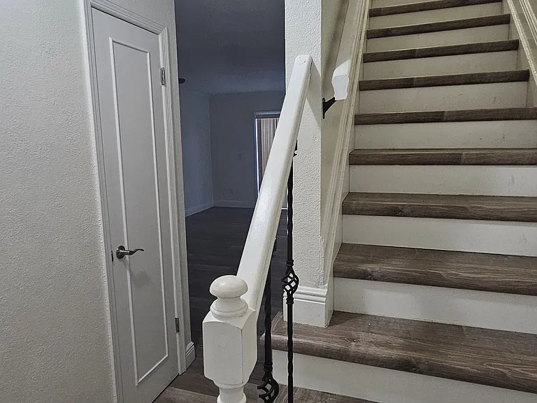 Photo from entrance to show the stairs to the top floor and to the living space and patio