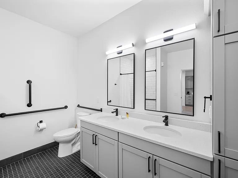 Modern bathroom with sleek double vanity, black fixtures, and spacious mirrors for contemporary aesthetics. Modern bathroom with sleek double vanity, black fixtures, and spacious mirrors for contemporary aesthetics.