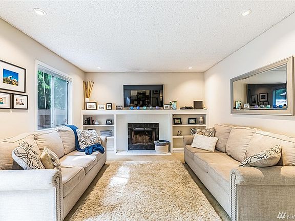 Family room with cozy wood-burning fireplace flanked by built-in bookcases.
