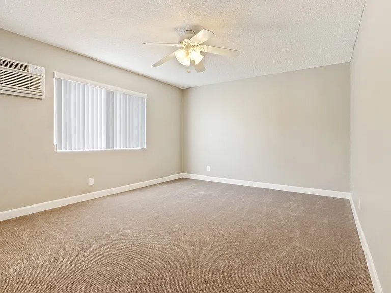 Bedroom with ceiling fan, vertical blinds on the window, air conditioning, carpet flooring