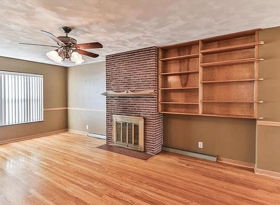 Spacious light filled living room with beautiful refinished wood floors