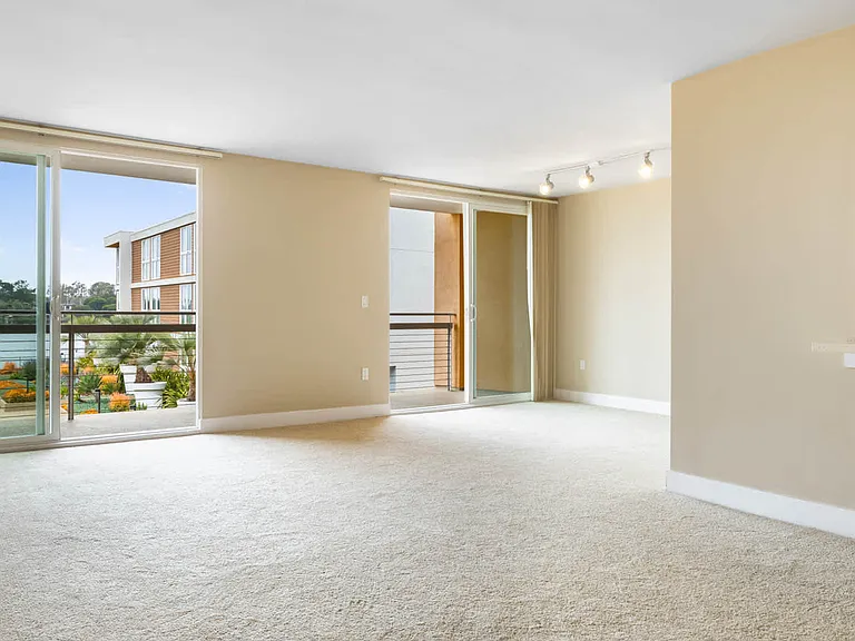 Carpeted Living Room with Balcony