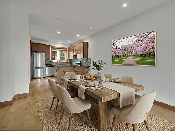 Open dining area flows seamlessly into the kitchen, featuring hardwood floors and a functional layout perfect for everyday meals, hosting friends, or relaxed family dinners.