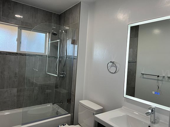 Newly Remodeled Bathroom with large back lite mirror & Glass Shower door