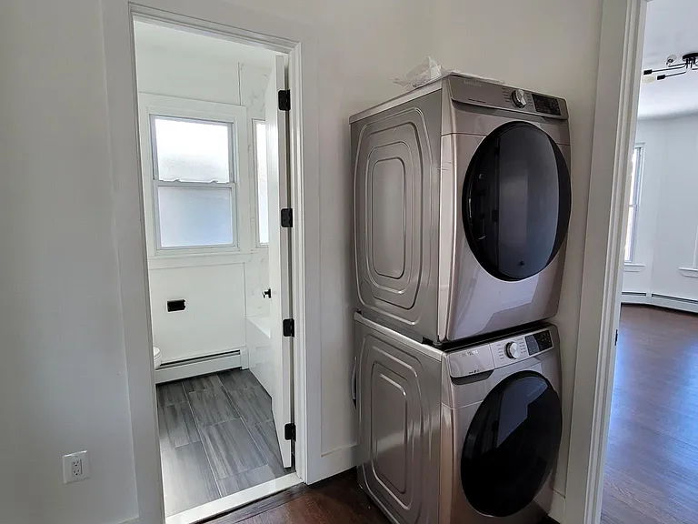 Since this photo, a casing was put around the washer/ dryer with a cabinet on top