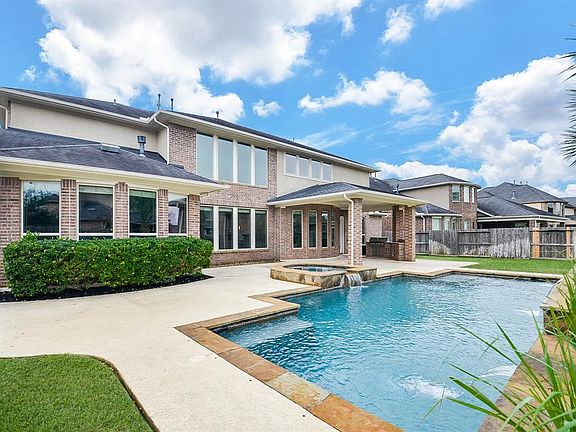 Beautiful Pool and Spa in the back yard and looking at the wall of windows on the back of the home. Nice gathering space for outdoor entertainment.