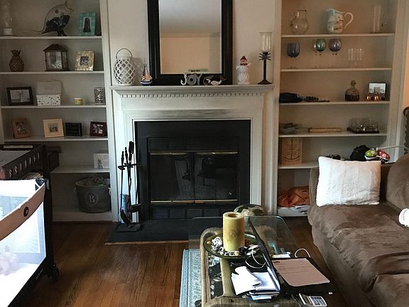 Living room with bookshelves and wood burning fireplace