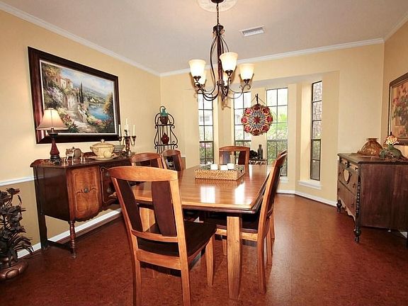 The formal dining room features beautiful decorator colors offset with white crown molding and chair