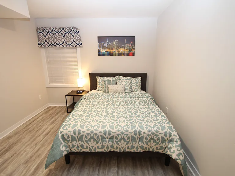 Cozy third bedroom with comfortable bedding and modern finishes.