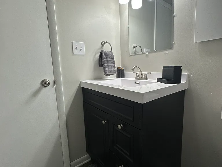 807 Second full bath all updated with plank floor, sink / vanity, mirror, lighting, and toilet located off the second entry.