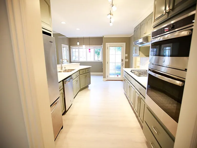 Open kitchen layout with stainless steel appliances, including a 4-burner gas range stove, full oven, built-in microwave, dishwasher, and lots of counter space and storage throughout. Plenty of room for multiple cooks in the kitchen and for guests to hang