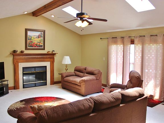 Great Room with Fireplace, Vaulted Ceilings, Skylights and Door to Large Deck.