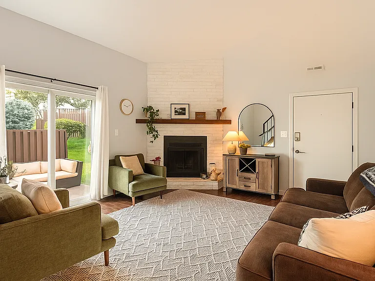 Enjoy the inviting warmth of a fireplace and plush seating, with natural light pouring in from the private patio doors.