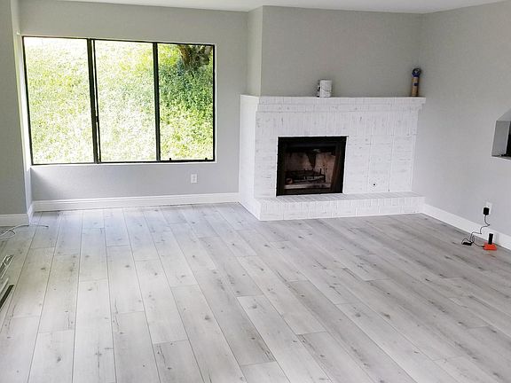 Living Area, light grey walls, bright whits baseboard and high end LVP without furniture