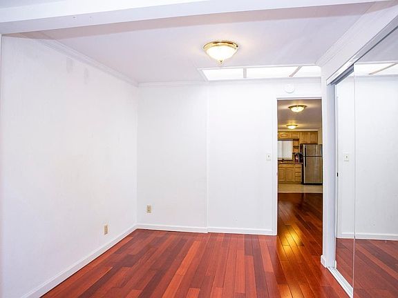 Bedroom with mirrored closet doors. Additional storage behind bedroom entry door.