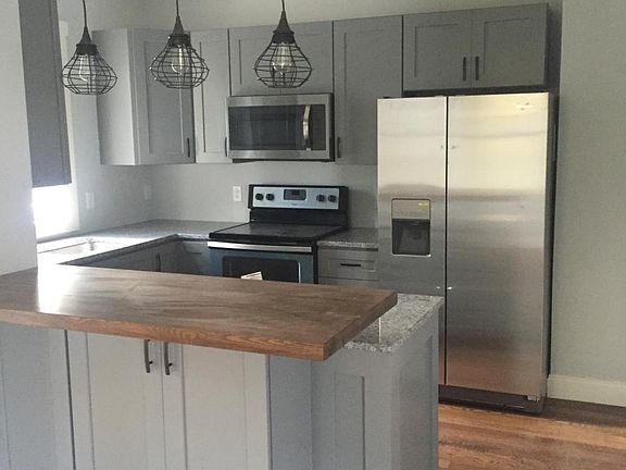 Kitchen with stainless steel appliances, butcher block bar a