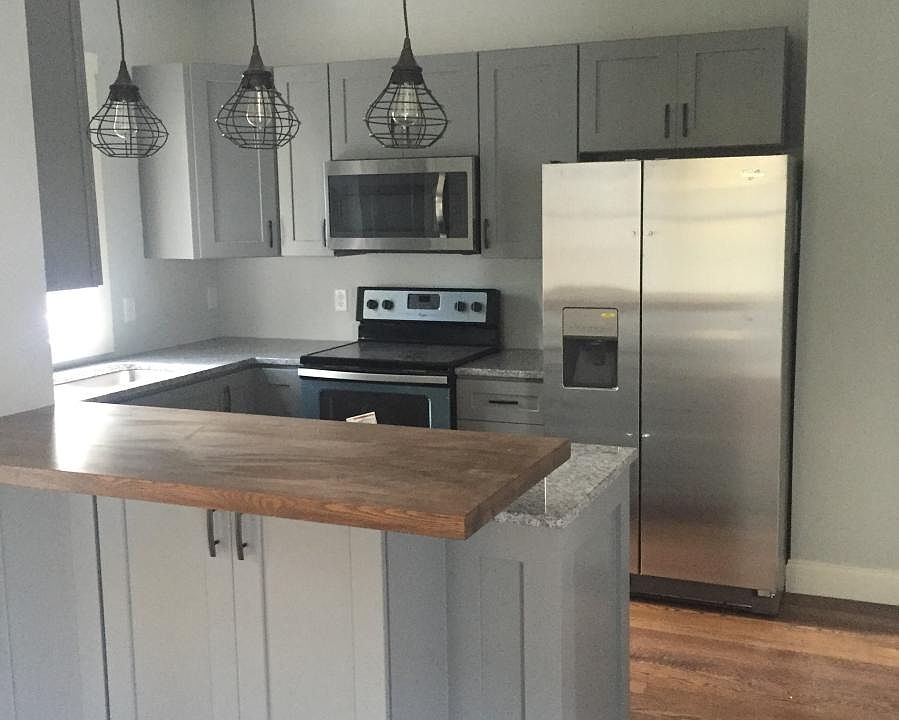 Kitchen with stainless steel appliances, butcher block bar a