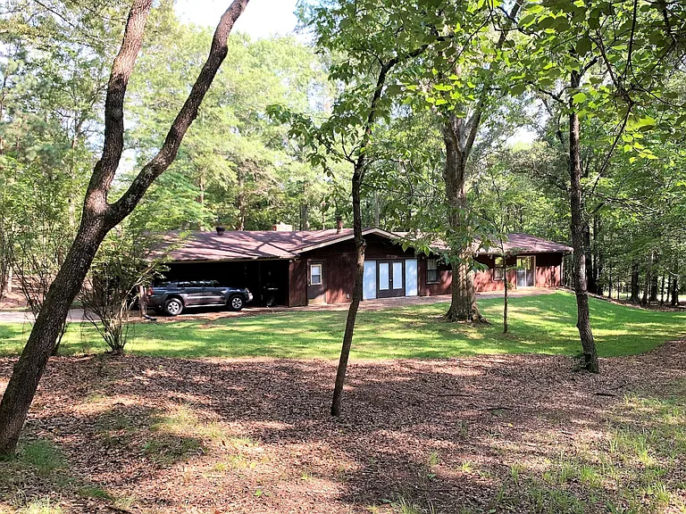 Rear view showing backyard and 2-car covered parking.