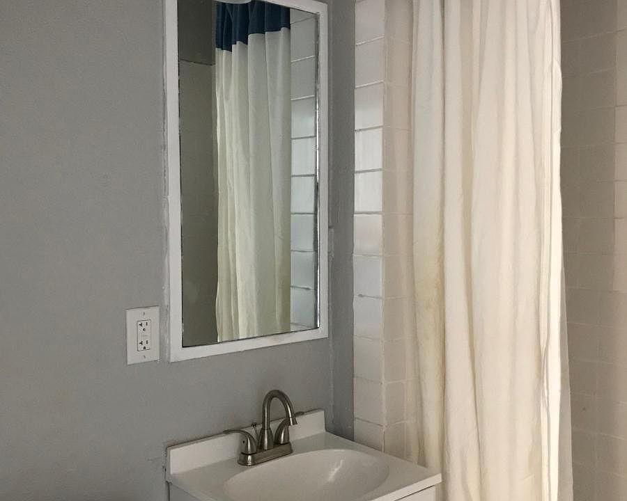 Bathroom with new tile, toilet, vanity and fixtures.
