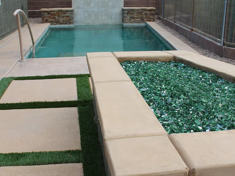 Heated swimming pool with water fall. Along with a beautiful gas fire pit.