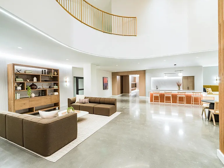 An inviting lounge with open seating, warm finishes, and a bar designed for gathering.