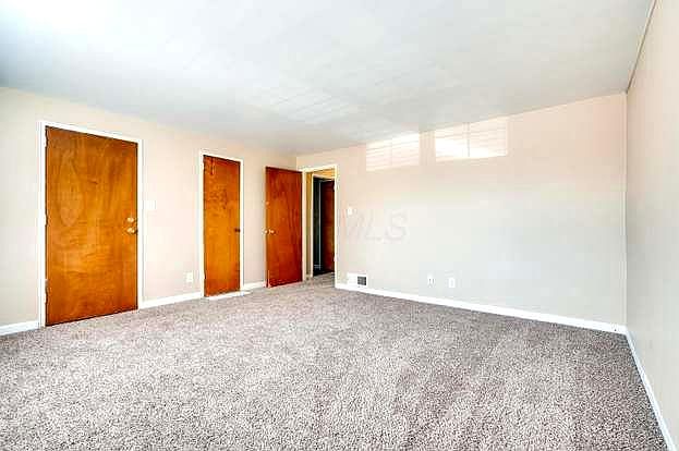 Large living room with new carpet. Closet space leads to the hallway for the kitchen, bedroom, and full bath with bathtub.