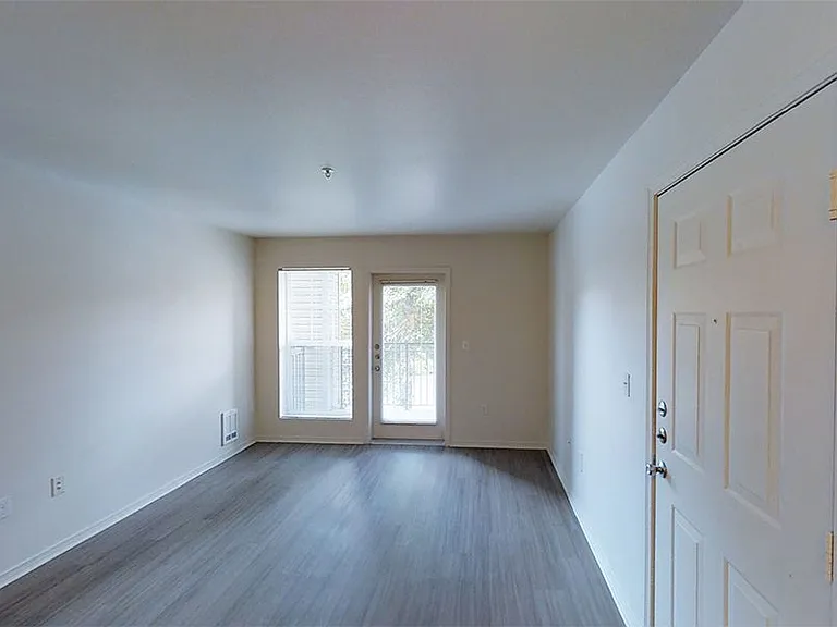 Apartment living room with plush carpet flooring.