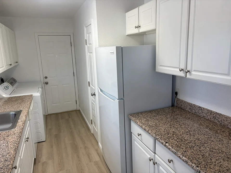Kitchen with updated appliances, including a refirgerator.