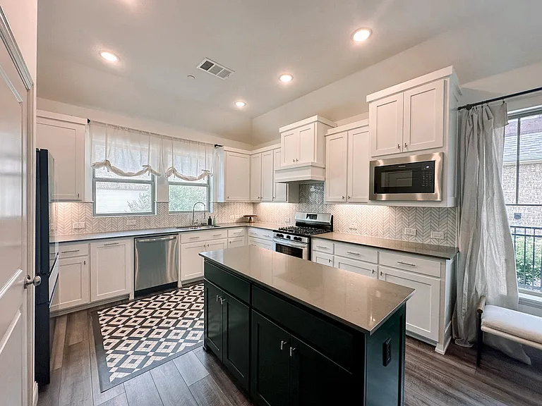 Light and open kitchen with tons of counter space with sink with a view