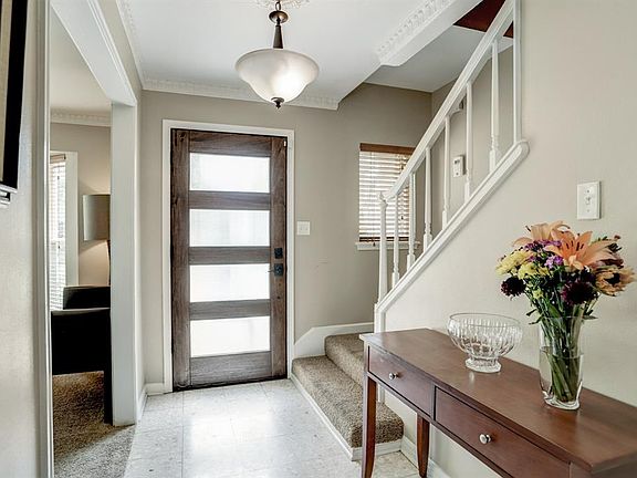 Foyer with terrazzo tile and updated reeded glass front door.