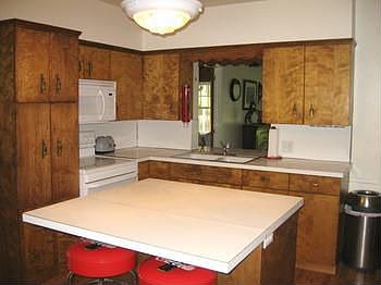 A convenient island in a kitchen full of cabinets plus a pantry