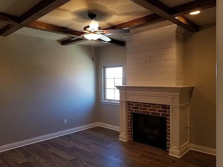 main bedroom with ceiling beams and fireplace