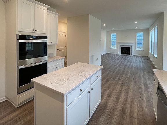 Island kitchen with white appliances and counters in a DRB Homes Bristol II Plan at the Villas of So