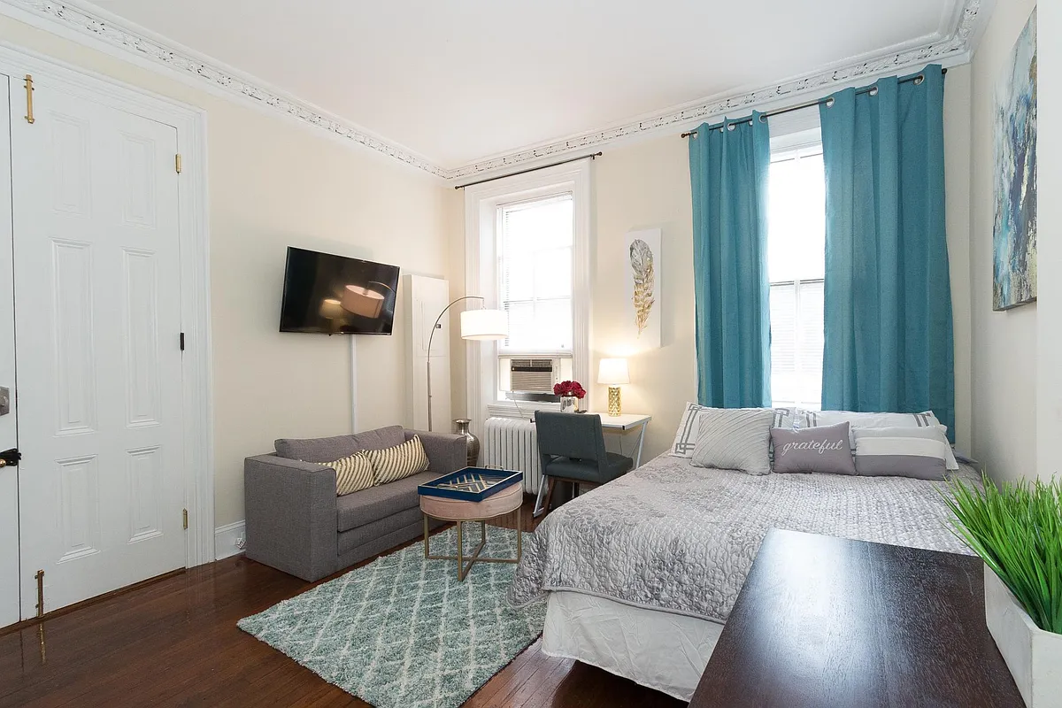 Living space / bedroom with wall mounted tv and sofa, high ceiling - 144 11th St SE #1