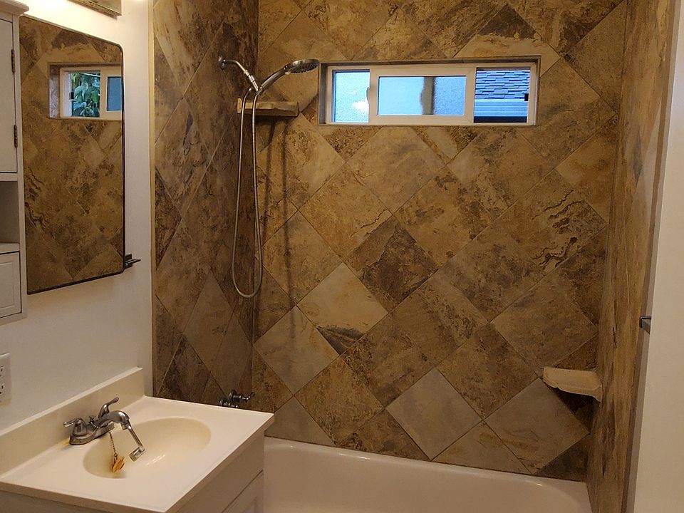 Tile bathroom with tub/shower, window ventilation and skylight.