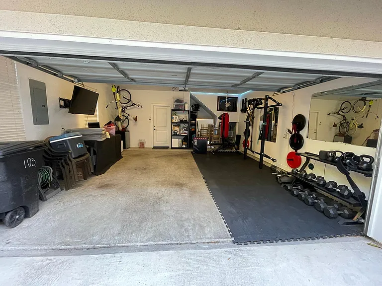 Two car garage. Weight room folds into the wall and comes with the property. TV comes with the property. Work bench and storage units, not included. Fits two SUVs.