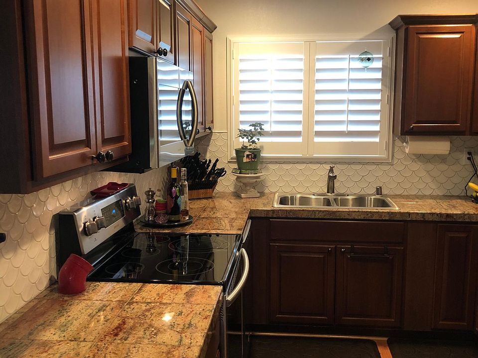Fully remodeled kitchen with granite counters and fishtail tile backsplash. New shutters in kitchen and all new appliances including garbage disposal.