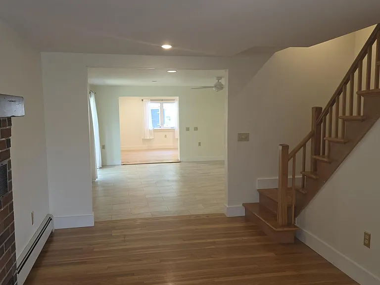 Dining Room Leading Into Living Room and Stairway Leading To Second Floor Bedrooms And Bath