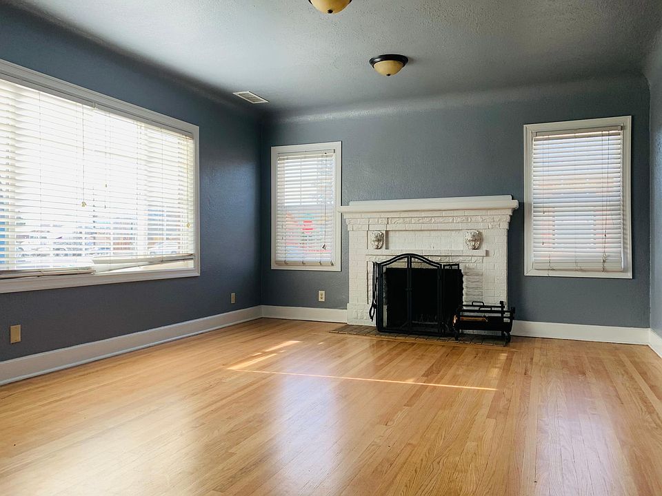Large sunny living area with solid Oak floors, "french grey" walls, and venetian blinds