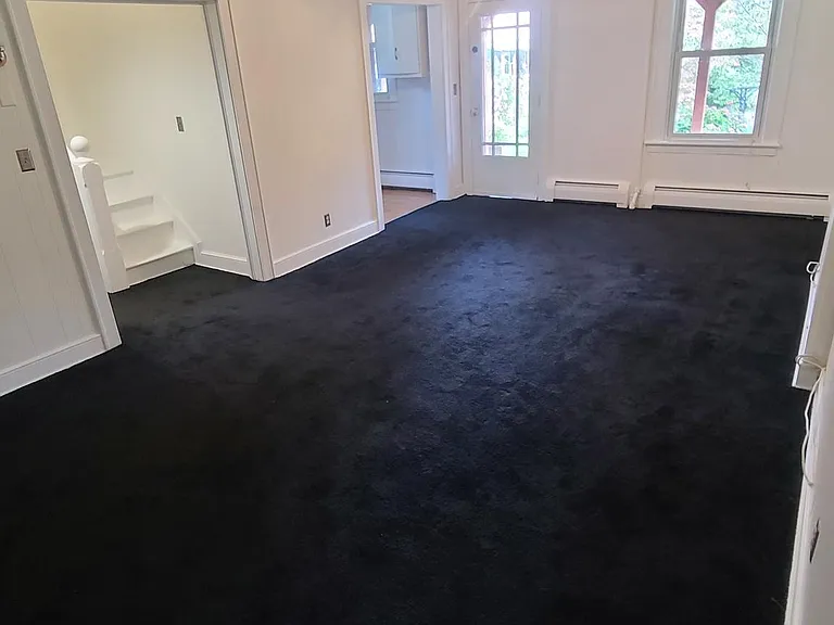 Living room/dining room opposite angle facing the front entrance.