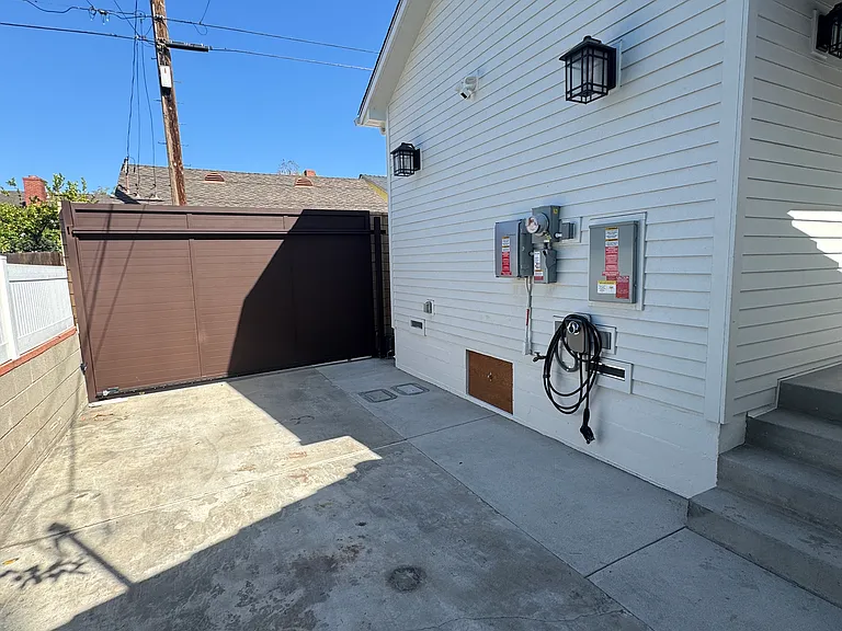 Lower side of house with EV charger and parking plus large eight foot sliding remote controlled gate