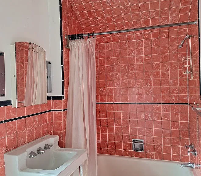 full bath is located upstairs, vintage pink tile is in great shape