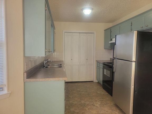 Kitchen with laundry area behind louvered door